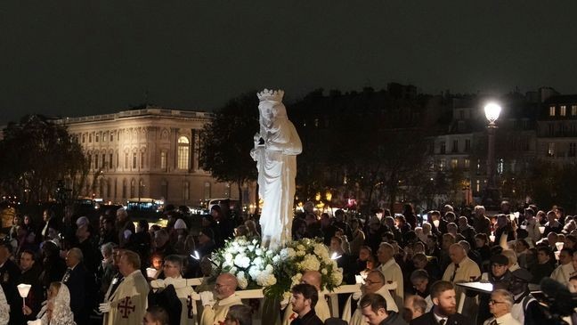 A replica of the Virgin Mary statue is carried from Saint-Germain l'Auxerrois church to Notre-Dame cathedral during a procession, Friday, Nov. 15, 2024 in Paris. (AP Photo/Christophe Ena)