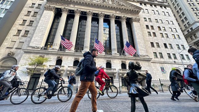FILE - A man passes the "Fearless Girl" statue in front of the New York Stock Exchange in New York on Friday, November 3, 2023. (AP Photo/Ted Shaffrey)